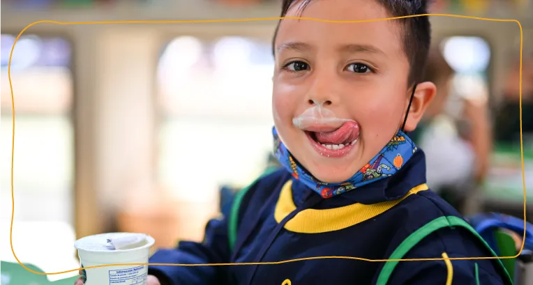 niña lamiendo bigote de leche